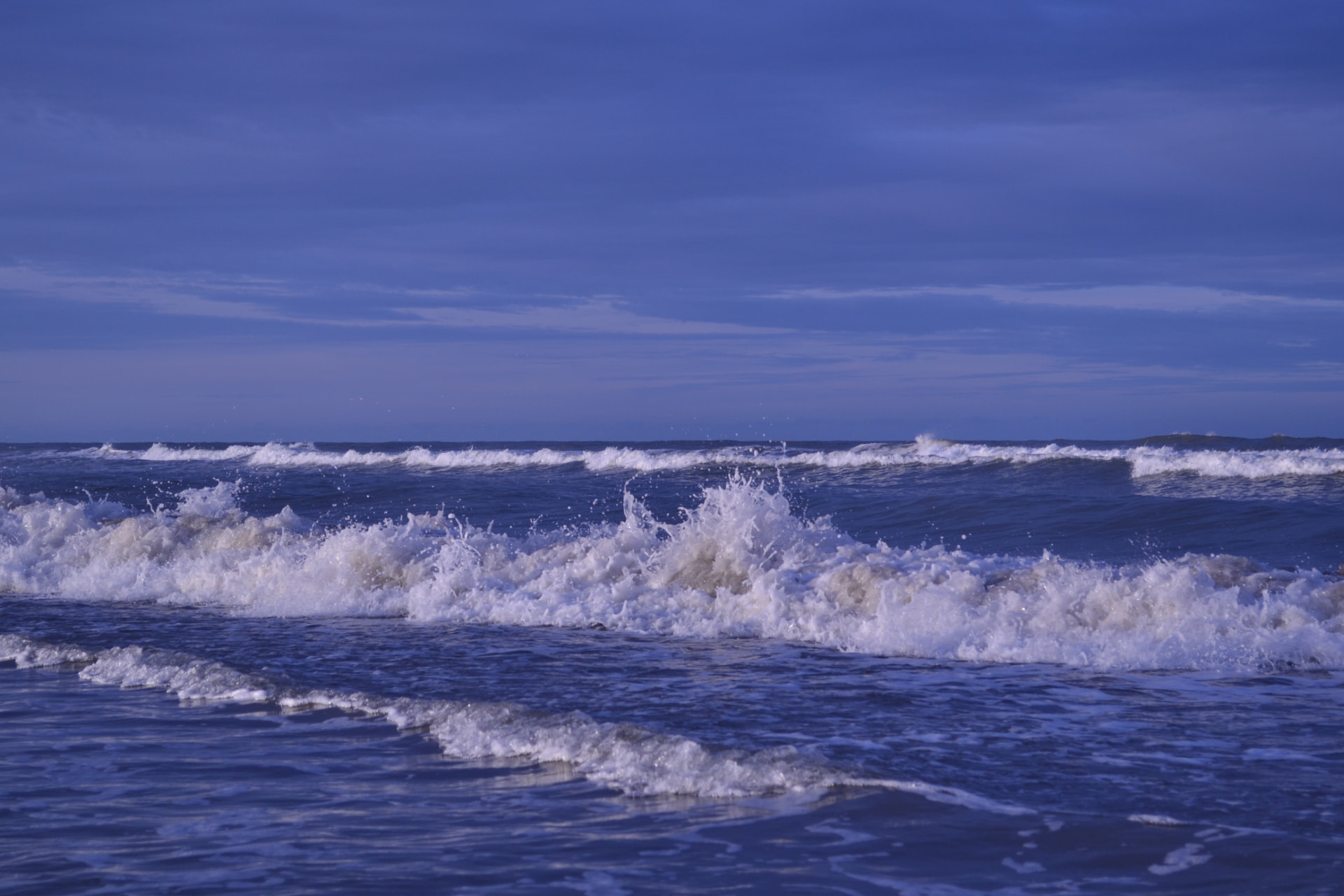 Olas rompiendo bajo un cielo azul